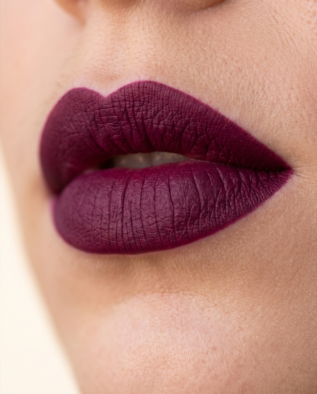 Close-up of lips wearing a deep velvet matte berry shade with crisp edges